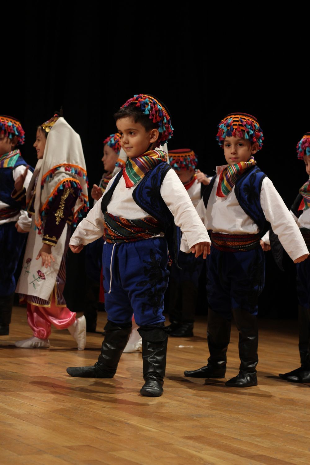 Students performing a traditional folk dance on stage