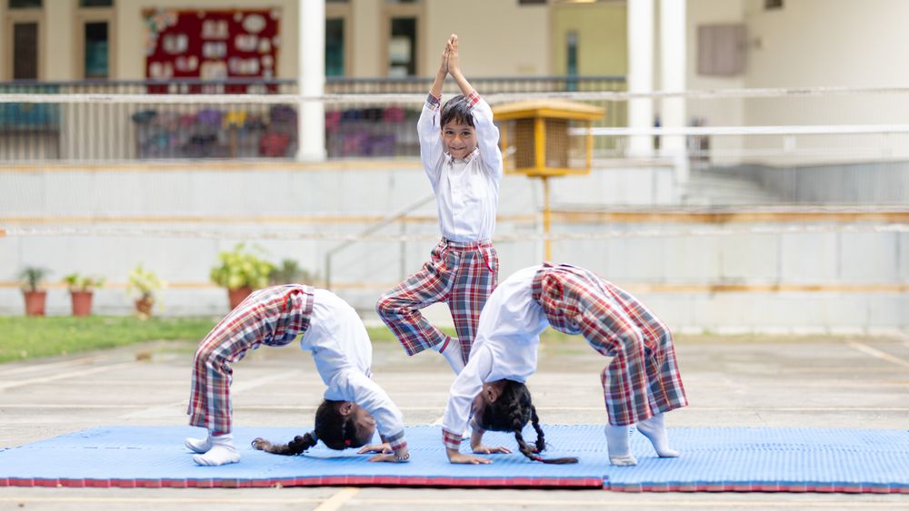 Children practising yoga outdoors at school