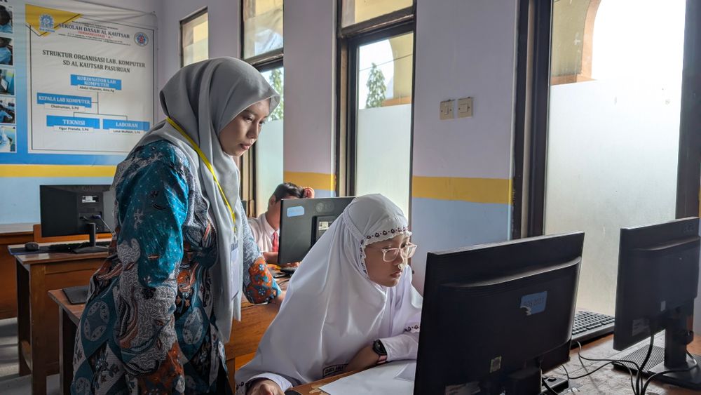 A teacher helping a student in the computer lab